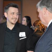 An alumnus enjoys conversation with T. Haas